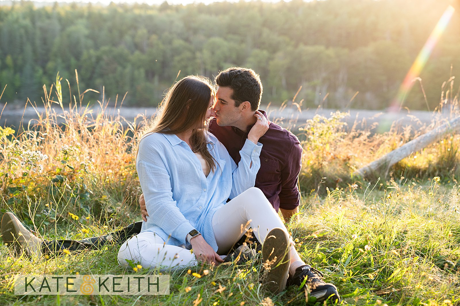 Engagement couple sitting in grass, Acadia National Park