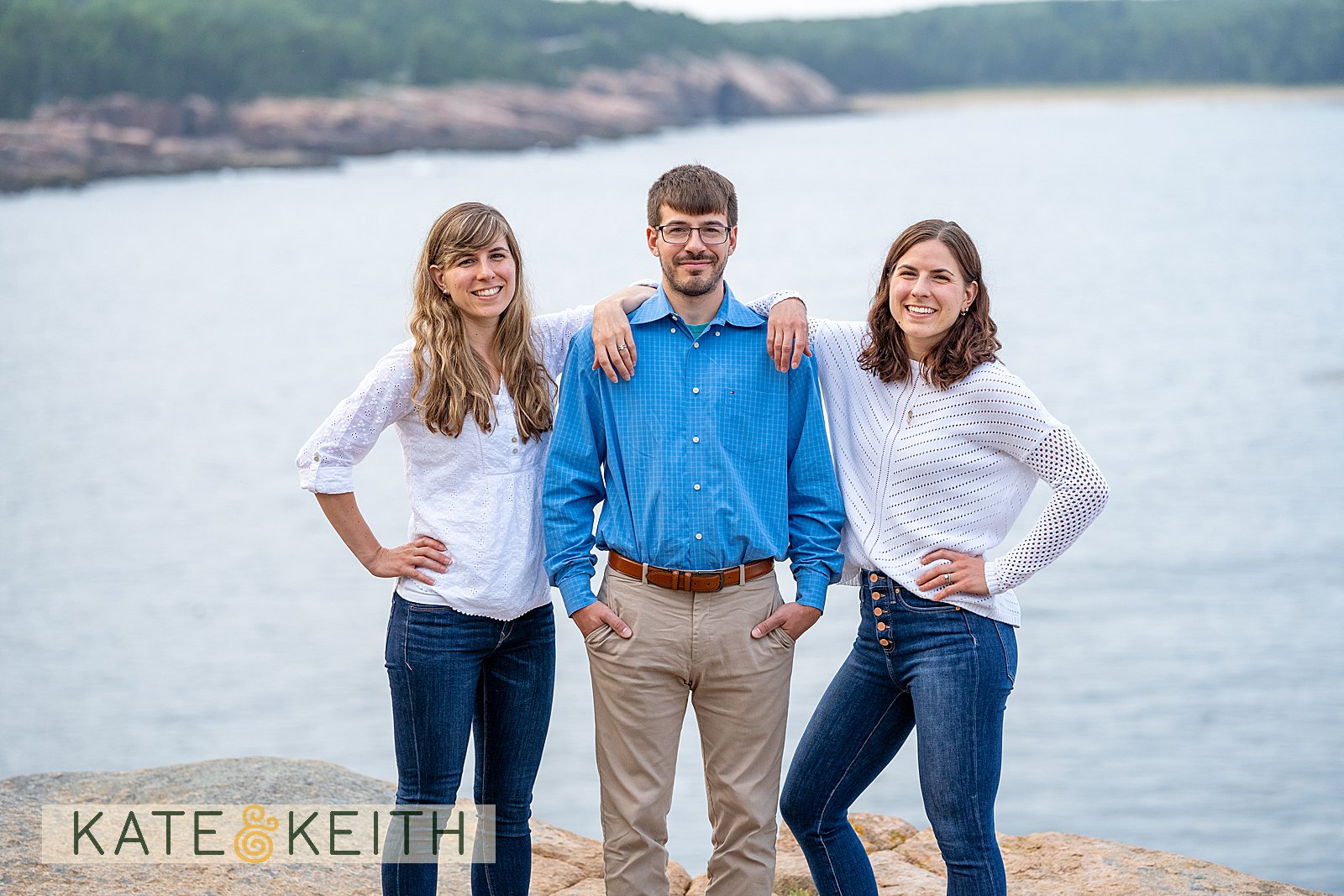 adult siblings posing on rocks with Acadia National Park as a backdrop
