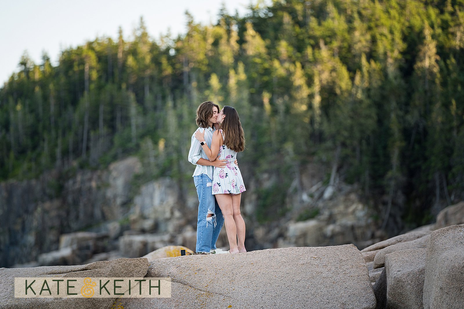 a couple kissing with Acadia National Park in the background