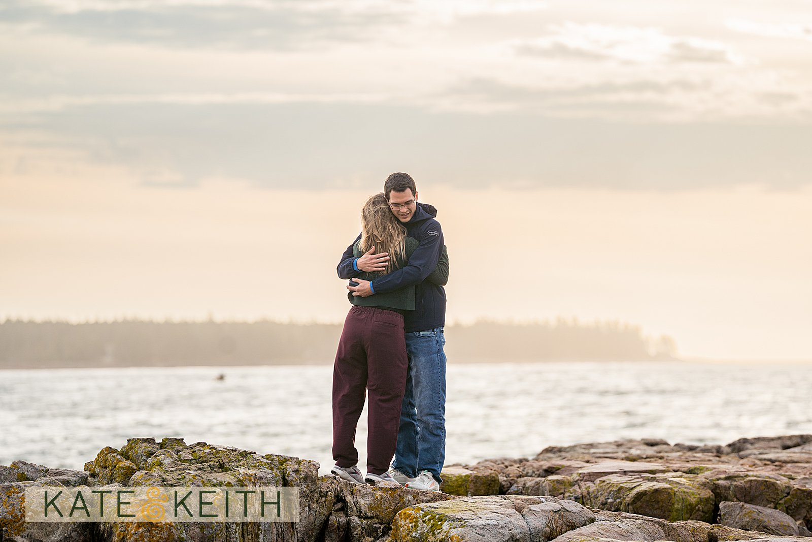 newly engaged couple hugging at Acadia coastline